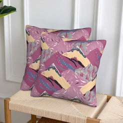Set of two velvet pillow covers with mauve and beige mountains, styled on a woven chair