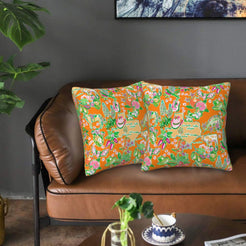 Velvet pillow covers with orange playful animal motifs, styled on a sofa