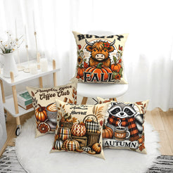 Four cream fall pillow covers with Highland cow, pumpkin spice, harvest and raccoon designs, styled on a bench