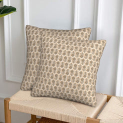 Velvet pillow covers with small taupe block-print-inspired motifs, styled on a woven chair