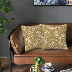 Bohemian velvet pillow covers with cream botanical silhouettes on ochre, styled on a brown leather sofa