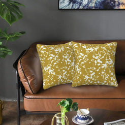 Bohemian velvet pillow covers with cream botanical silhouettes on mustard, styled on a brown leather sofa