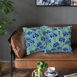 Velvet pillow covers with green and blue poppies, styled on a sofa
