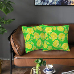 Velvet pillow covers with bright green and yellow chrysanthemums, styled on a sofa