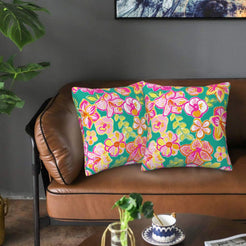 Velvet pillow covers with teal and pink orchids, styled on a sofa
