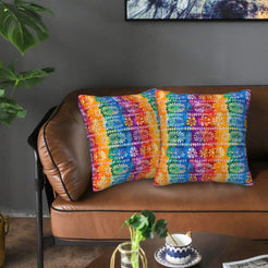 Mexican-inspired velvet pillow covers with rainbow floral tile bands, styled on a brown leather sofa