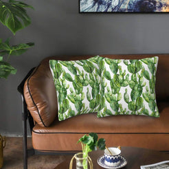 Mexican-inspired velvet pillow covers with green cactus plants on white, styled on a brown leather sofa
