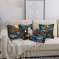 Four Christmas pillow covers with Santa, deer and snowy villages in stained-glass style, styled on a sofa