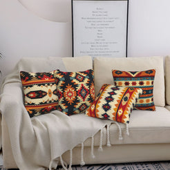short-pile plush polyester pillow covers with black, rust and cream Aztec geometric prints, styled on a cream sofa