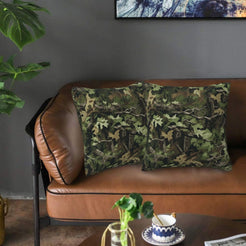 Velvet pillow covers with dark green leaf camouflage, styled on a sofa