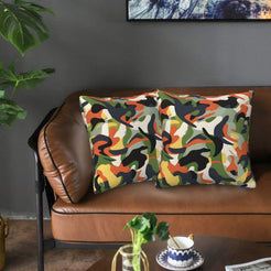 Velvet pillow covers with multicolor green and orange camouflage, styled on a sofa