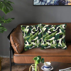 Velvet pillow covers with dark green woodland camouflage, styled on a sofa