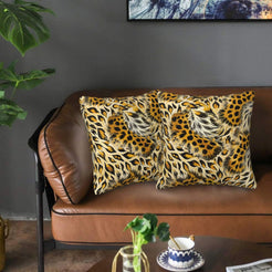 Velvet pillow covers with spotted cheetah and feathered markings, styled on a brown leather sofa