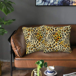 Velvet pillow covers with dense leopard and tiger stripes, styled on a brown leather sofa