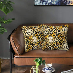 Velvet pillow covers with classic golden leopard rosettes, styled on a brown leather sofa