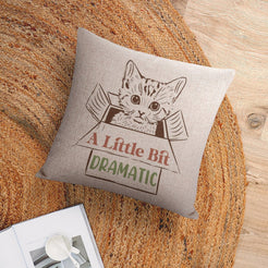 Linen-look pillow cover with cat and A Little Bit Dramatic quote, shown in a flat lay