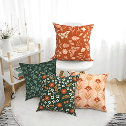 Rust and green botanical pillow covers styled in a bright room