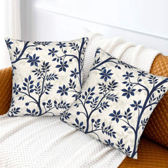 Block-print-inspired velvet pillow covers with navy flowering branches, styled on a sofa