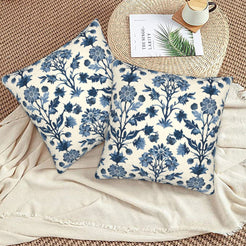 Block-print-inspired velvet pillow covers with navy tall floral stems, styled on a woven chair