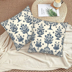 Block-print-inspired velvet pillow covers with navy folk floral trees, styled on a woven chair