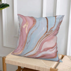 Short-pile plush pillow cover with blush, blue and rose marble designs, styled on a woven chair