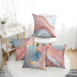 Four short-pile plush pillow covers with blush, blue and gold marble designs, styled in a bright room