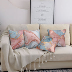 Four short-pile plush pillow covers with blush, blue and gold marble designs, styled on a sofa