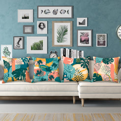 Short-pile plush pillow covers with coral, teal and mustard tropical leaves, styled on a cream sectional