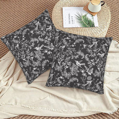 Toile floral velvet pillow covers with white birds and wildflowers on charcoal, styled on a woven chair