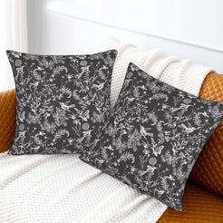 Toile floral velvet pillow covers with white birds and wildflowers on charcoal, styled on a sofa
