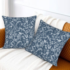 Toile floral velvet pillow covers with white birds and wildflowers on blue, styled on a sofa