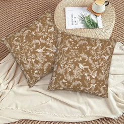 Toile floral velvet pillow covers with white birds and wildflowers on tan, styled on a woven chair
