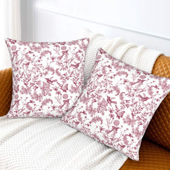 Toile floral velvet pillow covers with burgundy birds and wildflowers on white, styled on a sofa