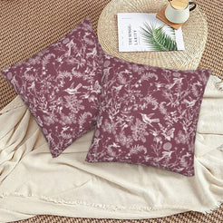 Toile floral velvet pillow covers with white birds and wildflowers on burgundy, styled on a woven chair