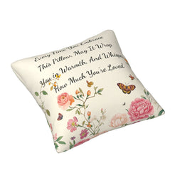 Angled view of a velvet pillow cover with cream floral pattern and heartfelt love quote