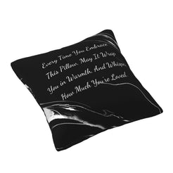 Angled view of a velvet pillow cover with black marble pattern and heartfelt love quote