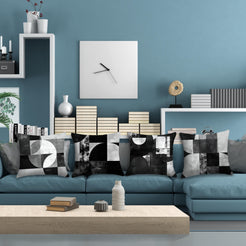 Short-pile plush pillow covers with black and gray Bauhaus-style geometry, styled on a blue sectional