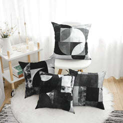 Short-pile plush pillow covers with black and gray Bauhaus-style geometry, styled in a bright room