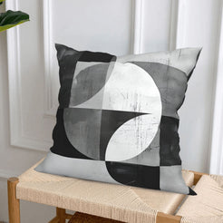 Short-pile plush pillow covers with black and gray Bauhaus-style curves, styled on a woven chair