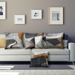 Short-pile plush pillow covers with gray, brown and black abstract geometry, styled on a gray sofa