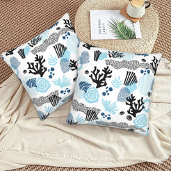 Coastal velvet pillow covers with abstract blue coral and shells, styled on a floor cushion