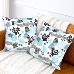 Coastal velvet pillow covers with abstract blue coral and shells, styled on a bed