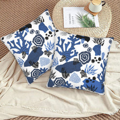 Coastal velvet pillow covers with blue coral garden motifs, styled on a floor cushion