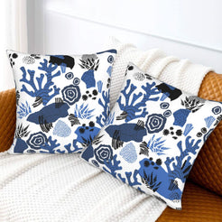 Coastal velvet pillow covers with blue coral garden motifs, styled on a bed