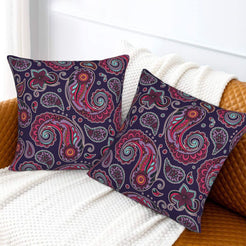Velvet pillow covers with small purple and magenta paisley, styled on a white sofa