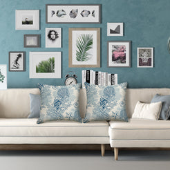 Water-resistant linen-look polyester pillow covers with blue shells, coral and seahorses, styled on a cream sofa
