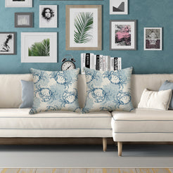Water-resistant linen-look polyester pillow covers with blue crabs and coastal line art, styled on a cream sofa