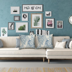 Water-resistant linen-look polyester pillow covers with blue jellyfish and coastal flowers, styled on a cream sofa