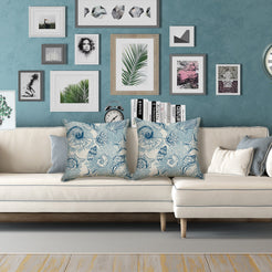 Water-resistant linen-look polyester pillow covers with blue shell and coral collage, styled on a cream sofa
