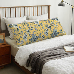 Mustard yellow toile body pillow cover styled across a bed